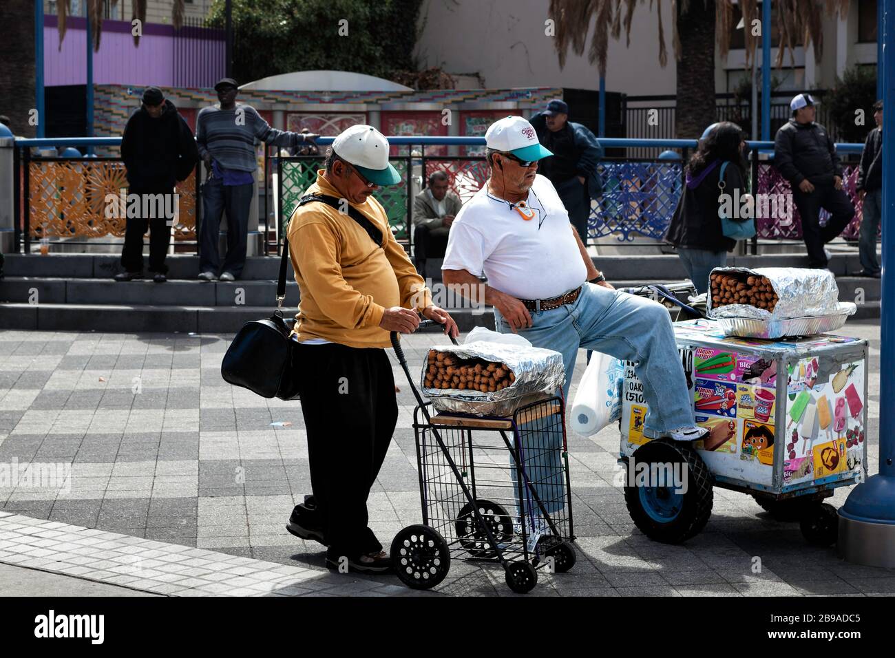 Händler von Churro und Lebensmittelkarren sprechen in einem Park, Mission District, San Francisco, Kalifornien, Vereinigte Staaten, Nordamerika, Farbe Stockfoto