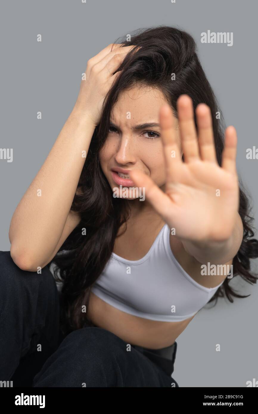 Schönes dunkelhaariges Mädchen in einem weißen Oberteil, das betont aussieht Stockfoto