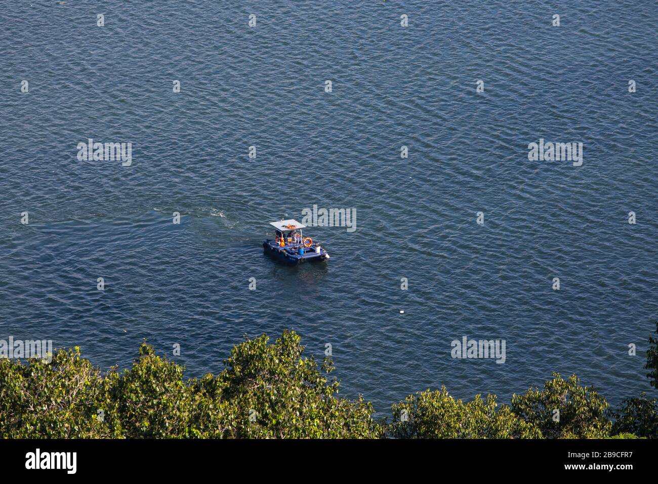 Aus der Vogelperspektive eines Reinigungsbootes, das Runden macht, um den Müll auf dem Wasser zu säubern, Singapur Stockfoto