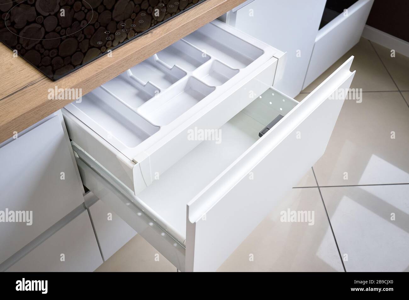 Lösung zum Aufstellen von Küchengeräten in die moderne Küche - horizontale ausziehbare Schubladeneinlegeböden im Schrank für kochgeschirr darunter Stockfoto