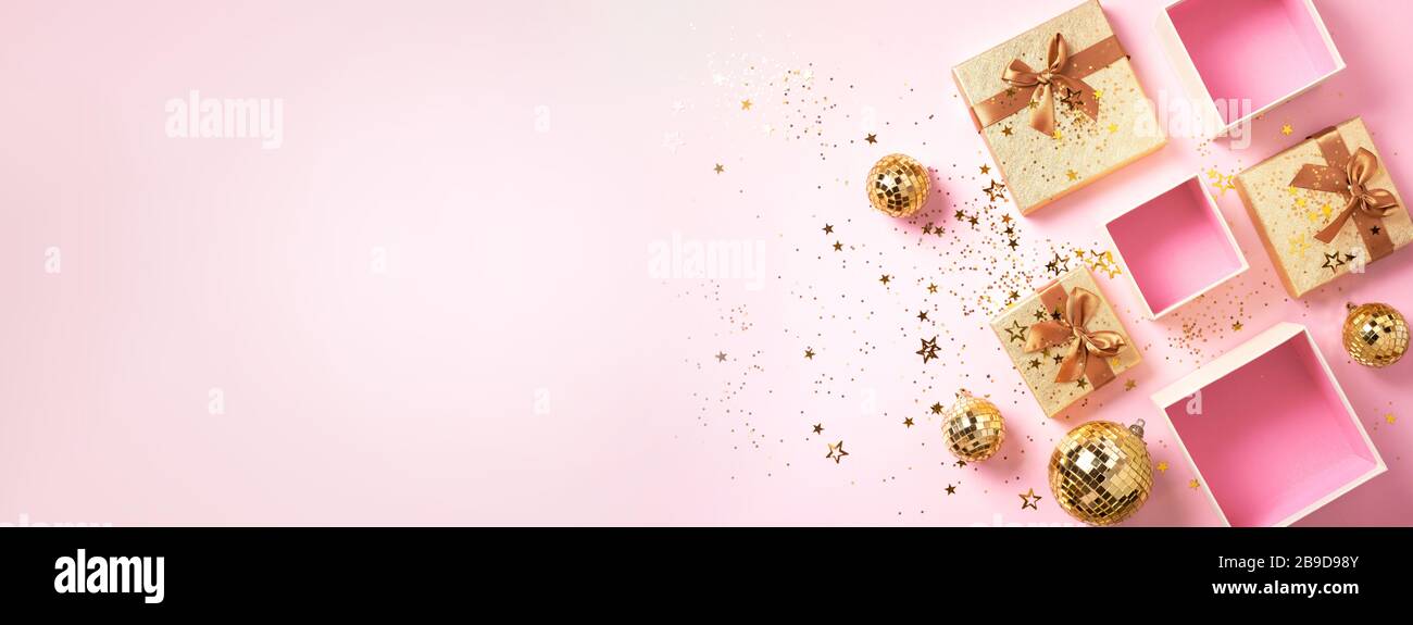 Geschenkbox, glänzende goldene Disco-Bälle, funkelnder Goldglitter auf pinkfarbenem Hintergrund. Neujahrssitzel, Sternenglitzern. Neujahr, Weihnachten, Valentinstag Con Stockfoto