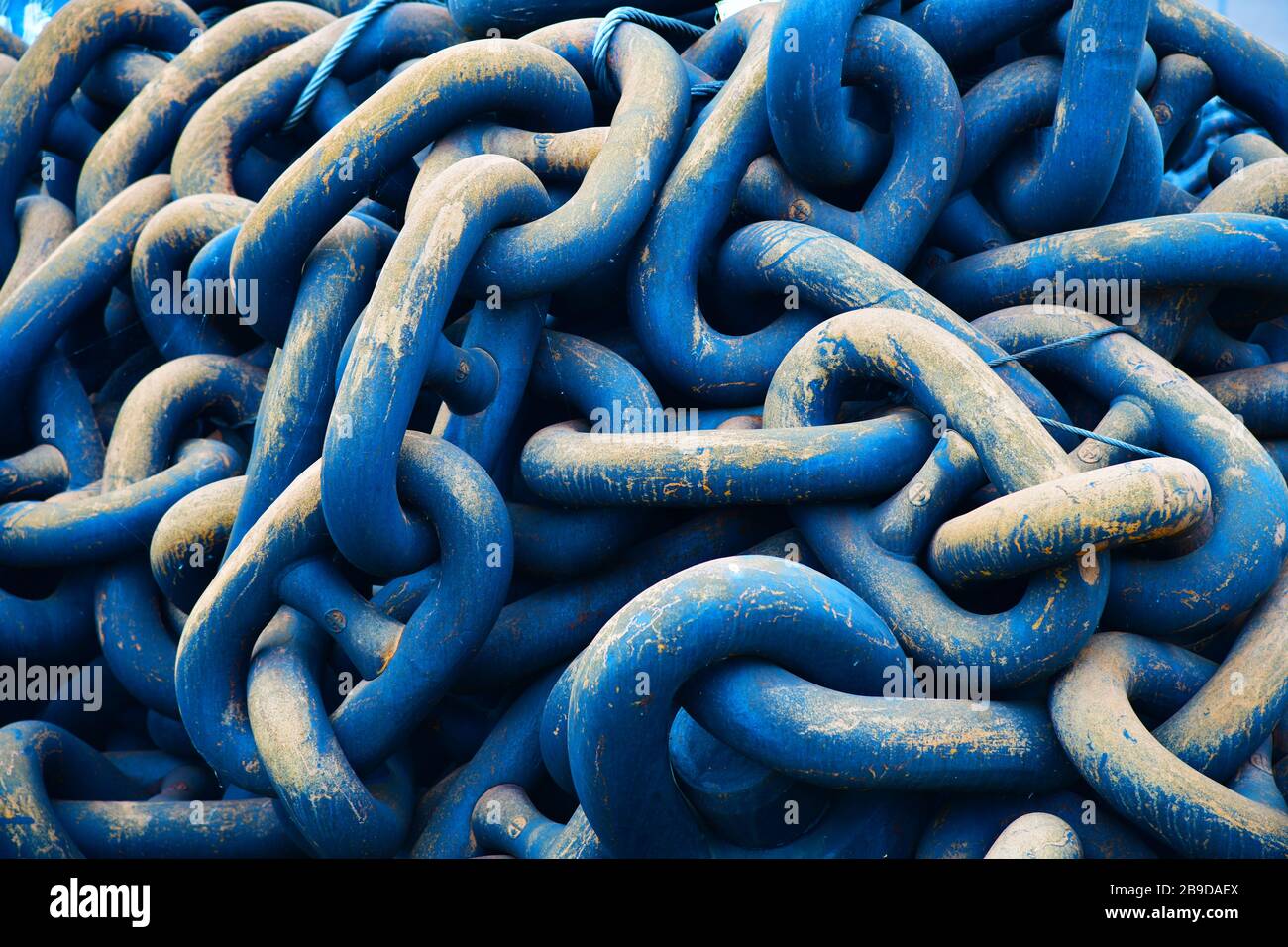 Im Hafen von Rotterdam türmen sich riesige schwere blaue Ankerketten auf, die zu wettern beginnen und kratzen Stockfoto