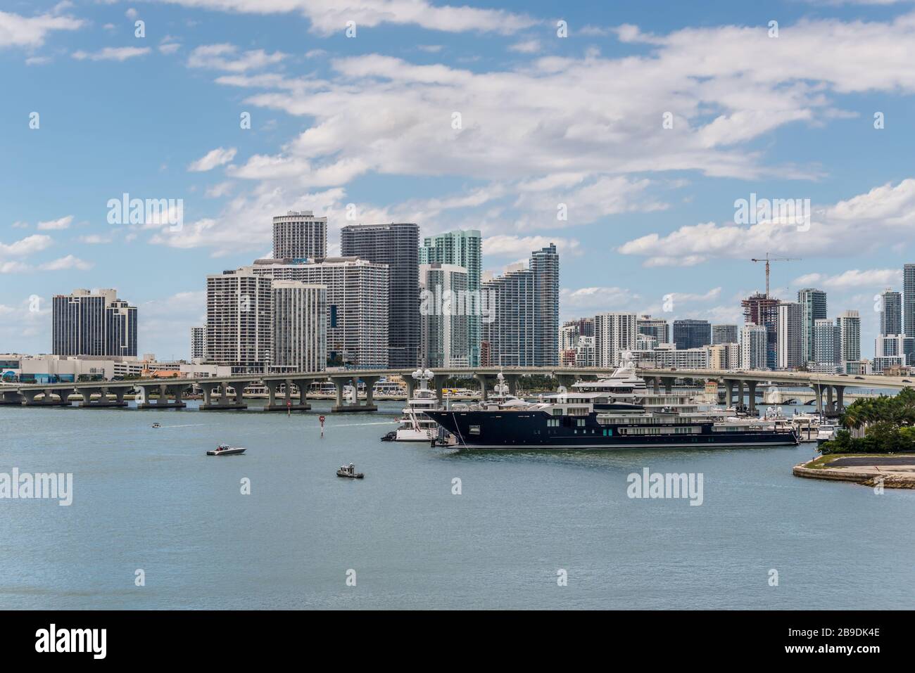 Miami, FL, Vereinigte Staaten - 20 April, 2019: Miami Skyline von Dodge Island an der Biscayne Bay gesehen. Lange Verkehr Brücke und Luxus Yacht in der Fo Stockfoto