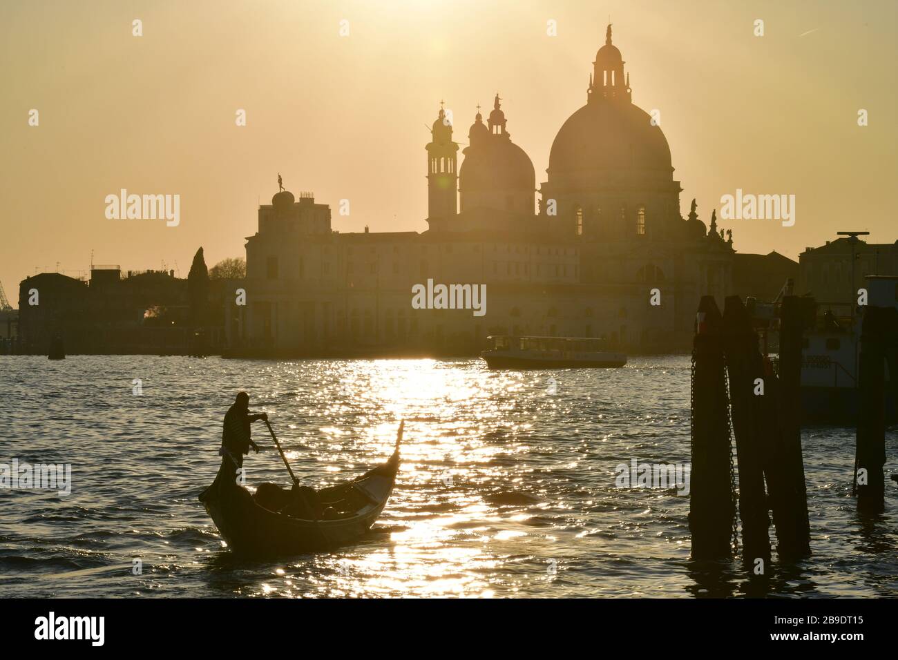 Gondel vor dem Hintergrund der Sonne hinter der Basilika von venedig Stockfoto