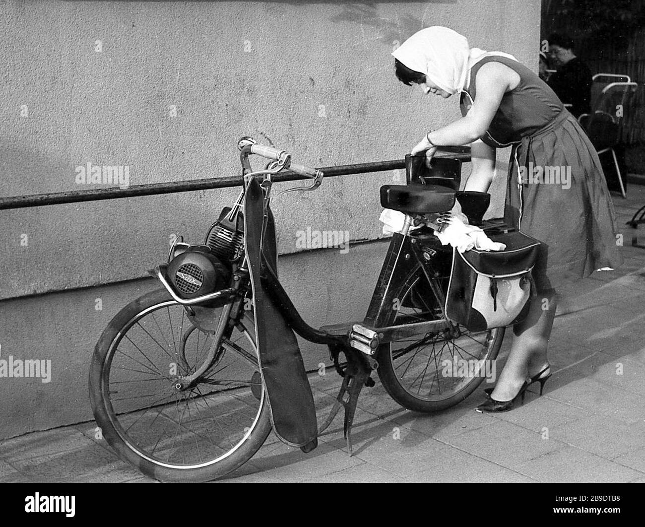 Eine junge Frau in Kehl an der deutsch-französischen Grenze 1965 hat ihr  Fahrrad einen sogenannten Hühnerschrecken, einen kleinen Zweitaktmotor, der  daran befestigt ist. [Automatisierte Übersetzung] Stockfotografie - Alamy