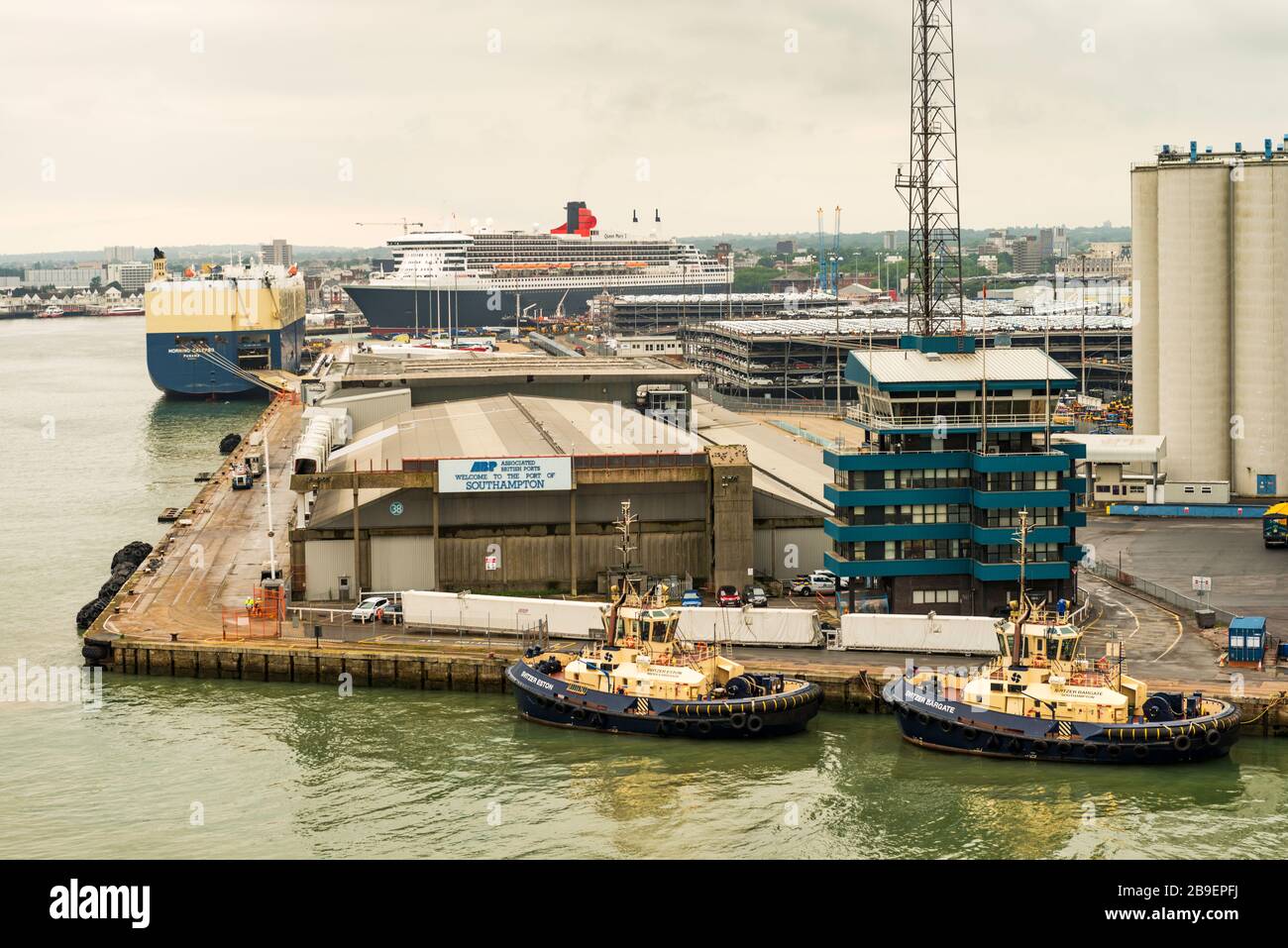 Ein Fahrzeugtransporter, Morning Calypso, und der Ozeandampfer "Cunard", RMS Queen Mary 2, werden im Hafen von Southampton, Hampshire, England, Großbritannien, verttert. Stockfoto