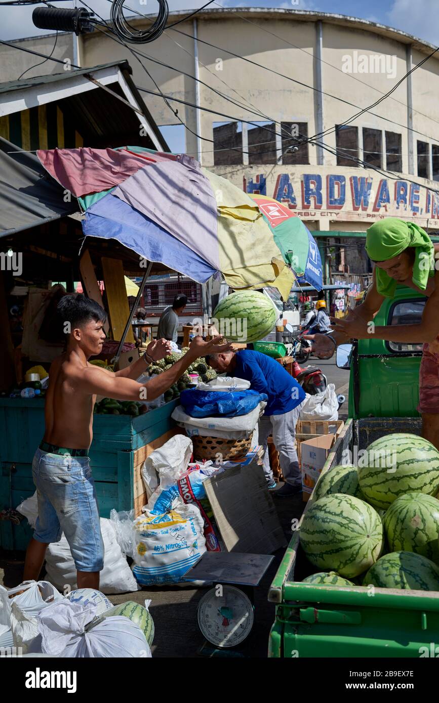 Träger laden einen LKW mit Wassermelonen in die Straßen des öffentlichen Carbon Marktes. Stockfoto