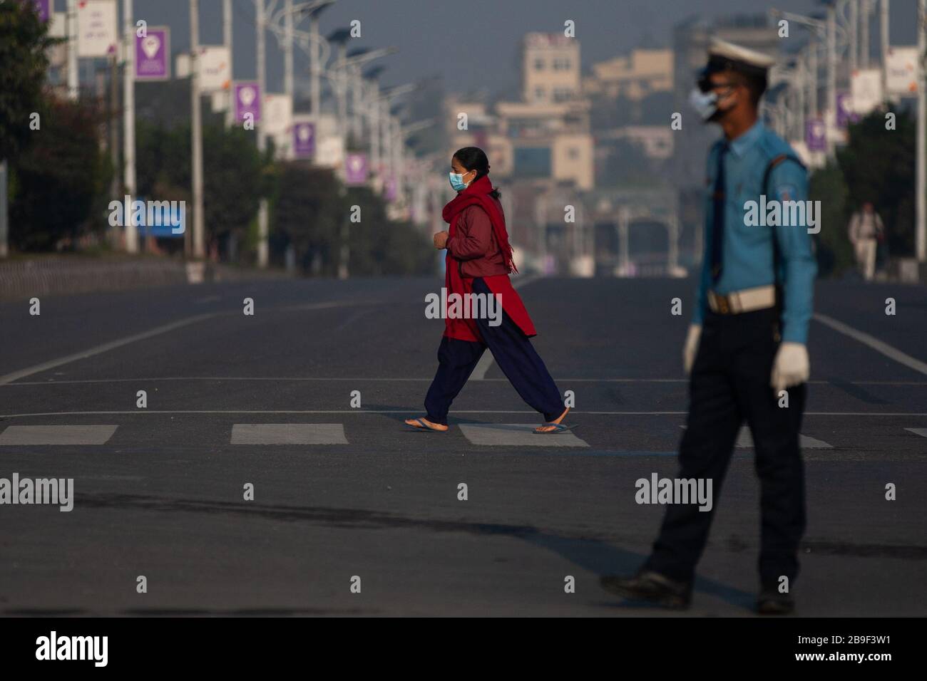 Kathmandu, Nepal. März 2020. Eine Frau, die eine Gesichtsmaske trägt, spaziert während der Sperre in Kathmandu über eine menschenleere Straße. Die nepalesische Regierung hat beschlossen, das ganze Land nach einem zweiten bestätigten COVID-19-Fall vom 24. März bis 31. März zu sperren. Credit: SOPA Images Limited/Alamy Live News Stockfoto