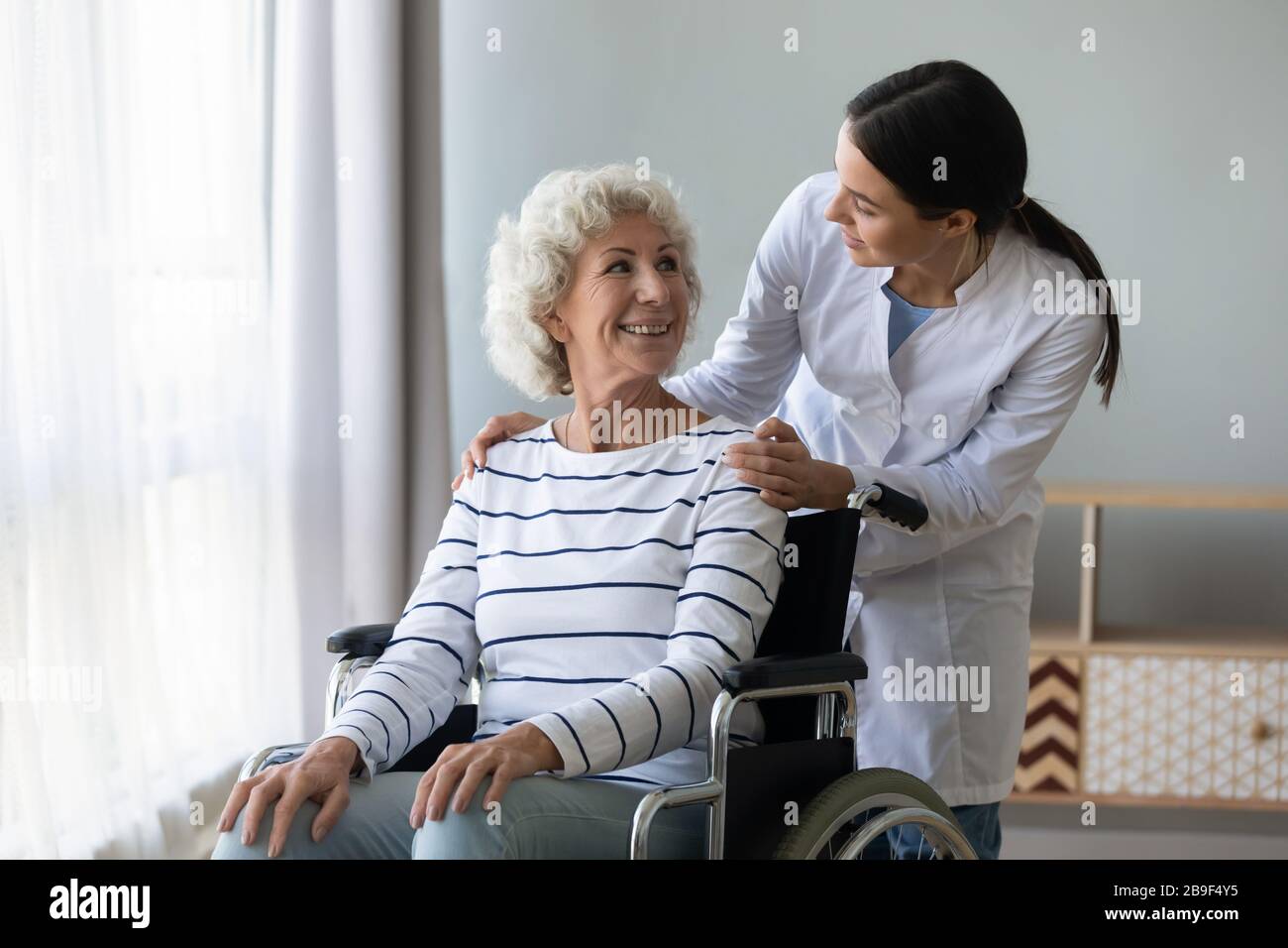 Weibliche Ärztin kümmert sich um behinderte Oberin Stockfoto