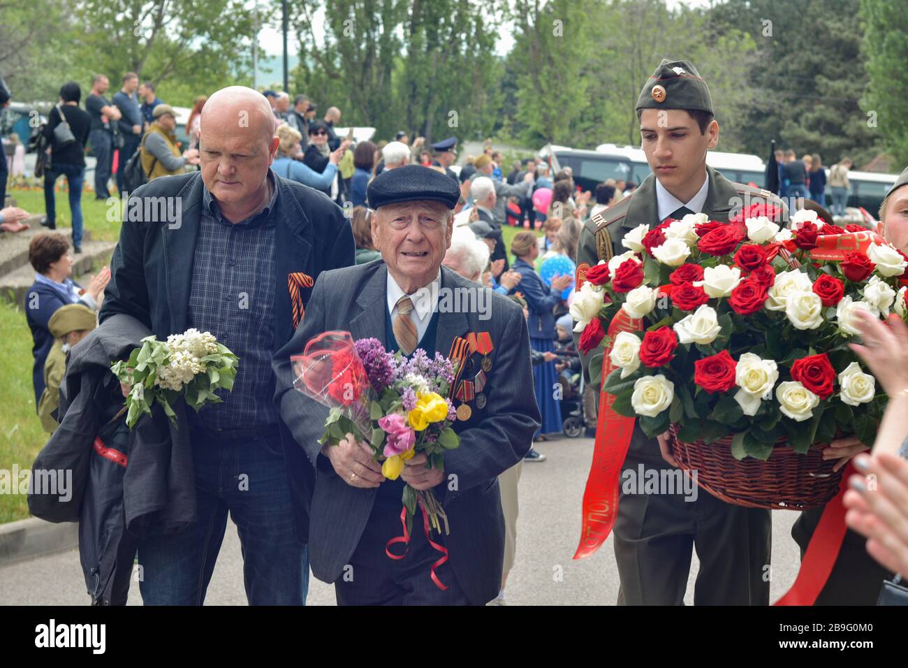 PYATIGORSK, RUSSLAND - 9. MAI 2017: Junger Pfleger und älterer Mann mit einem Gehstock am Siegestag Stockfoto