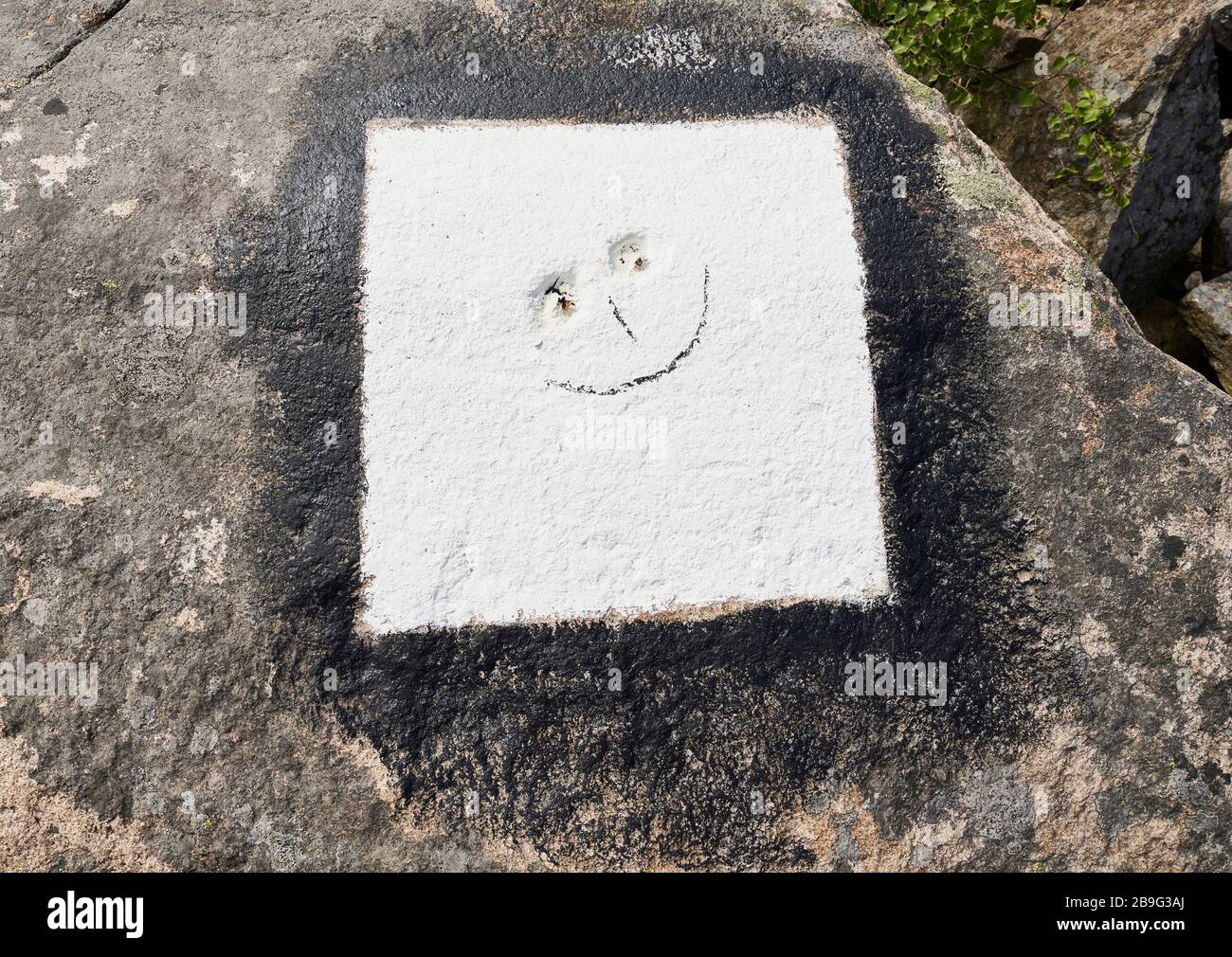 Smiley-Gesicht in weißem Beton Stockfoto