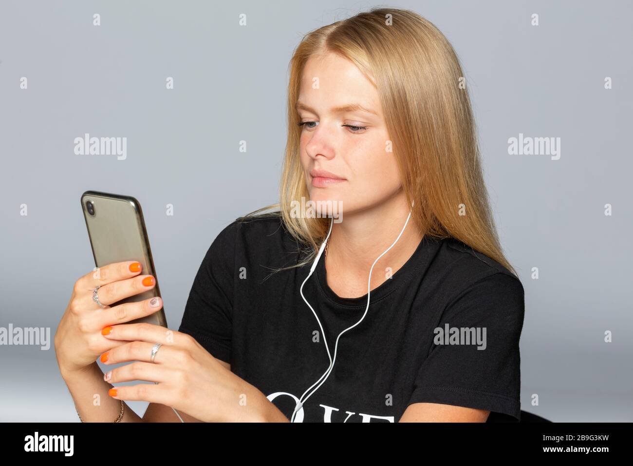 Junge Frau, die Musik mit Smartphone und Kopfhörer hört Stockfoto