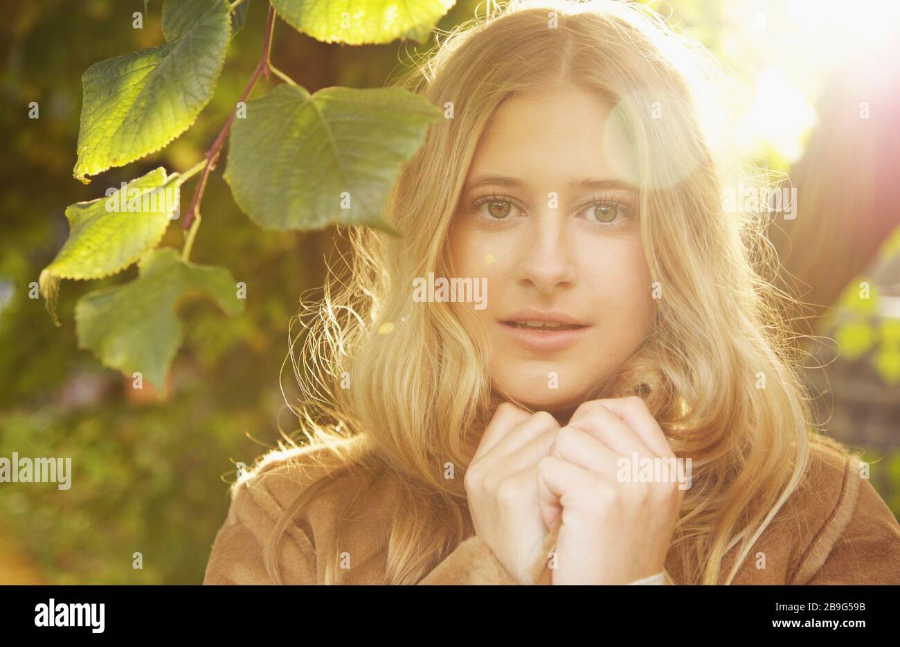 Portrait heiteres Teenager-Mädchen im sonnigen Herbstpark Stockfoto