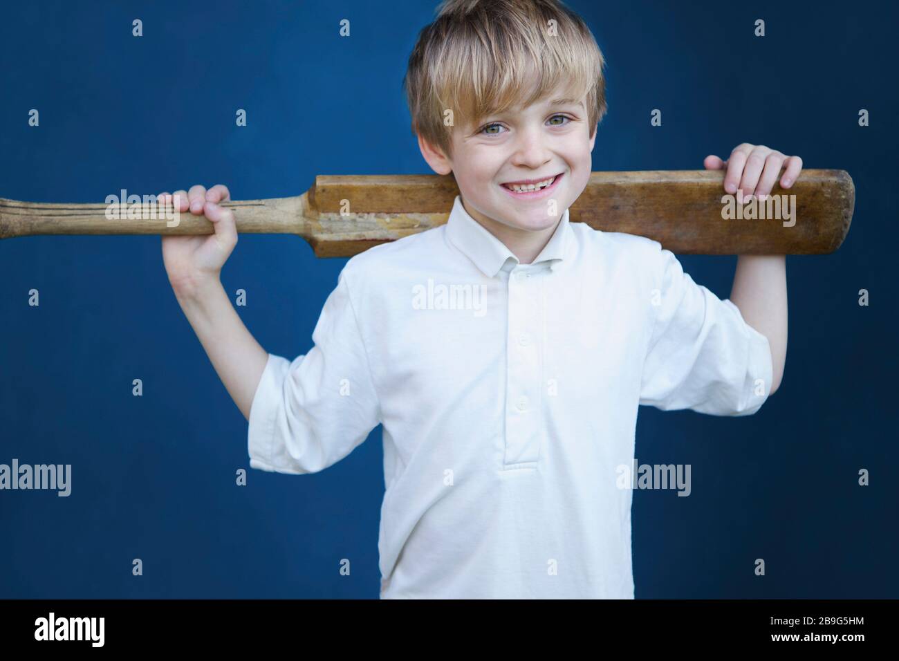 Portrait lächelnder Junge mit Kricketschläger Stockfoto