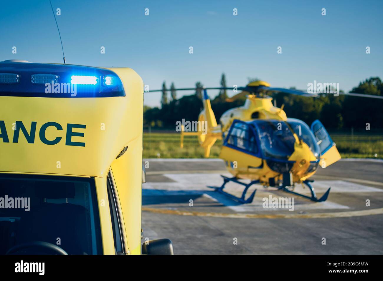 Rettungswagen gegen Hubschrauber des medizinischen Notdienstes. Selektiver Fokus auf blauem Blinker. Stockfoto