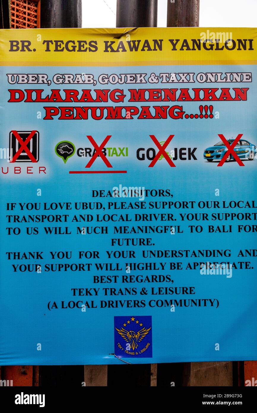 Ein Schild, in dem Touristen aufgefordert werden, Uber, Gojek und Grab Taxis nicht zu benutzen, sondern lokale Taxifahrer, Ubud, Bali, Indonesien zu benutzen. Stockfoto