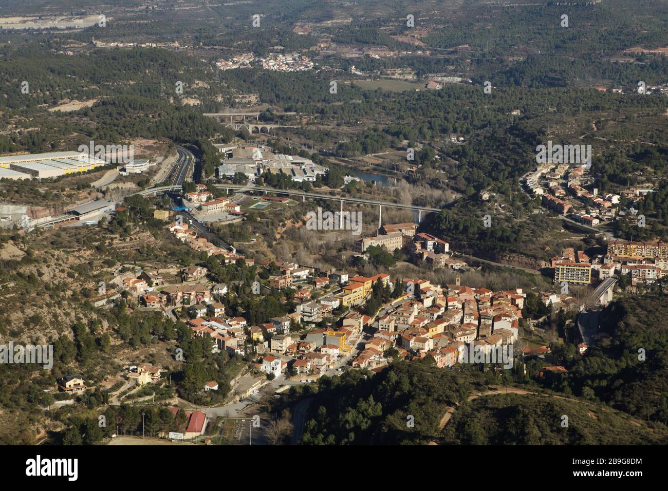 Luftbild der Stadt Monistrol de Montserrat aus der Kremallera de Montserrat, die Zahnradbahn, die die Stadt mit dem Montserrat-Kloster (Monasterio de Montserrat) verbindet, im Bergmassiv bei Barcelona, Katalonien, Spanien. Im Zentrum ist die Überführung der Zahnradbahn zu sehen, links der Bahnhof. Stockfoto