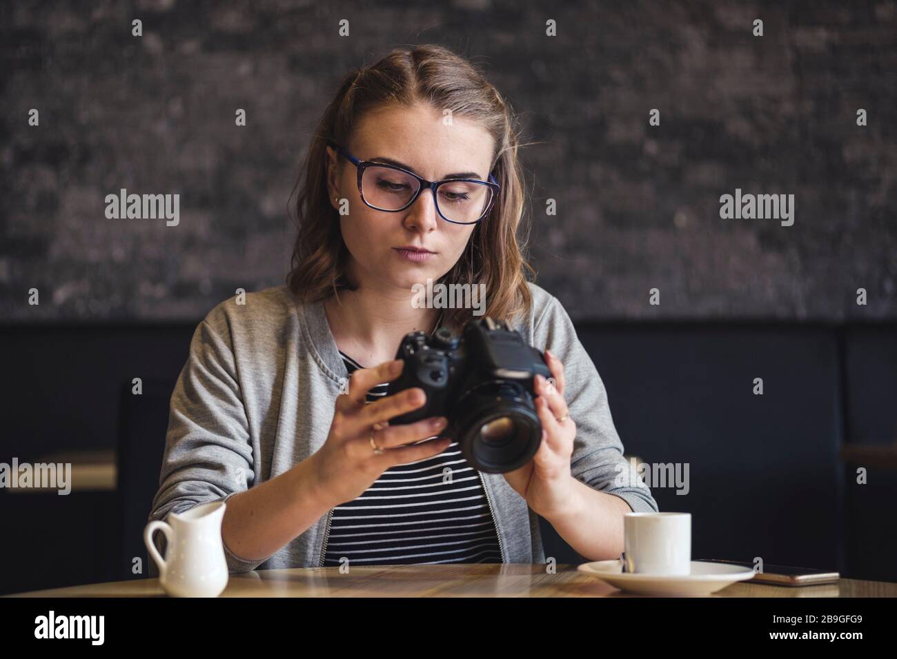 Junge Fotografin überprüft ein Bild, während sie entspannt Stockfoto