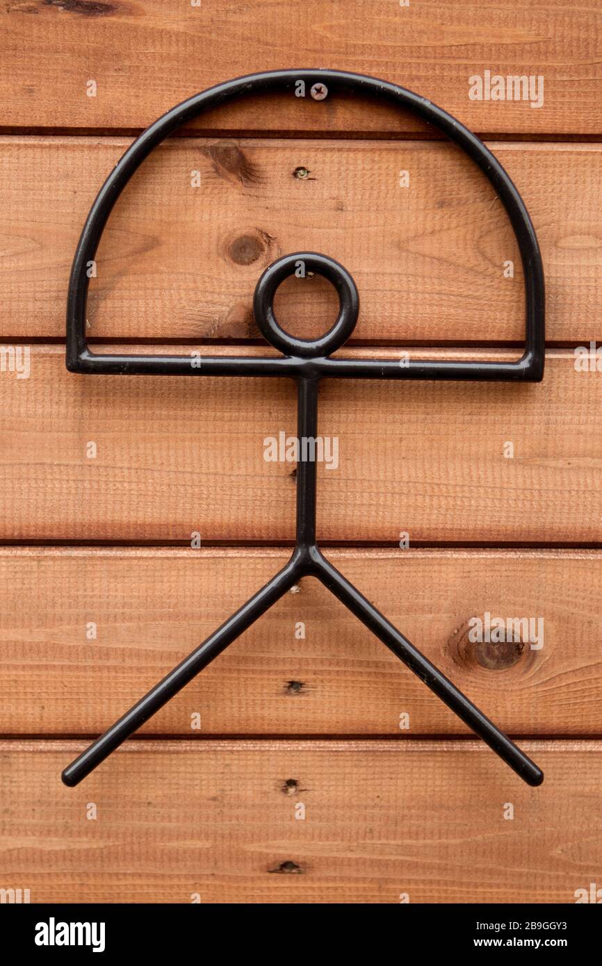 Metall-Indalo-Mann-Symbol an einem Holzzaun. Der Indalo ist ein uraltes Glückssymbol und wird als ein Knüppel dargestellt, der einen Regenbogen hält. Stockfoto