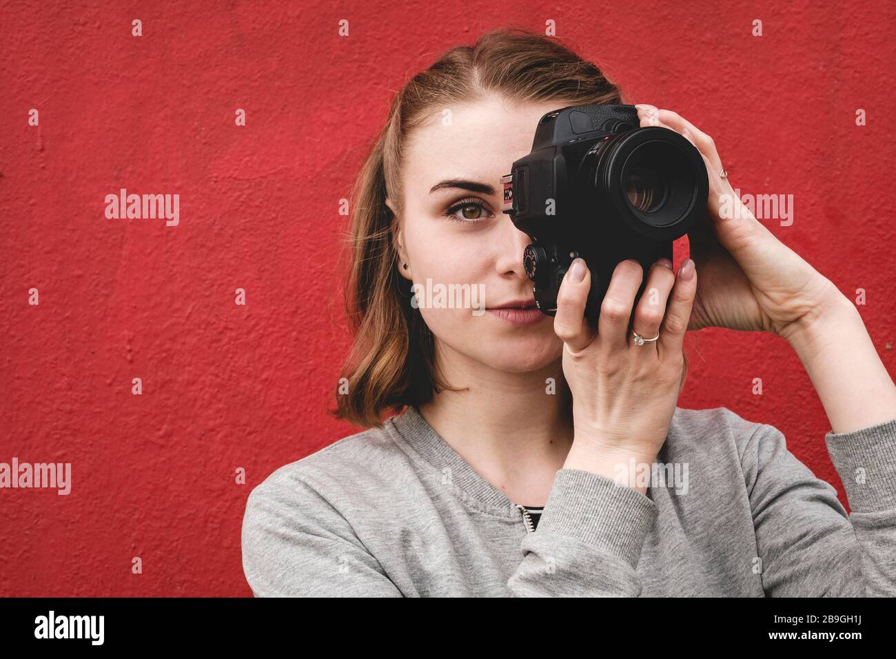 Fotografin hält im Porträt eine Kamera Stockfoto