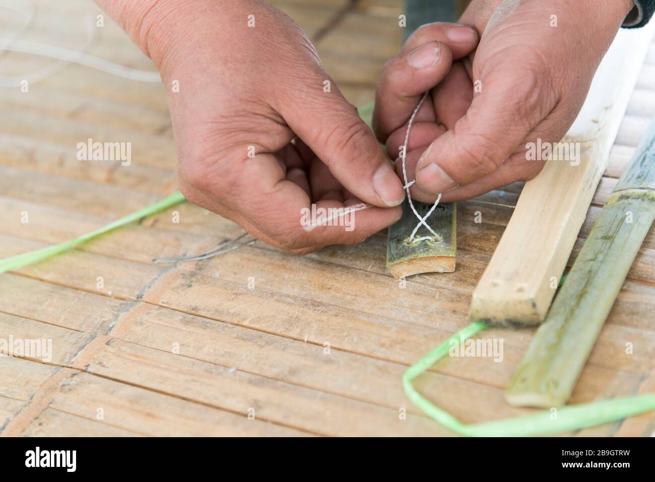 Ein Mann, der traditionellen chinesischen Bambus schlüpft Stockfoto