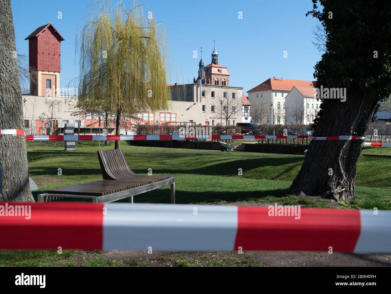 Luckenwalde, Deutschland. März 2020. Die Bänke im Nuthepark sind mit rotem und weißem Wegeband abgedrandet. Mit der Kennzeichnung will die Stadt das Verbot von Menschenmassen in Parks und öffentlichen Bereichen durchsetzen, das aufgrund der Corona-Pandemie erlassen wurde. Credit: Soeren Stache / dpa-Zentralbild / dpa / Alamy Live News Stockfoto