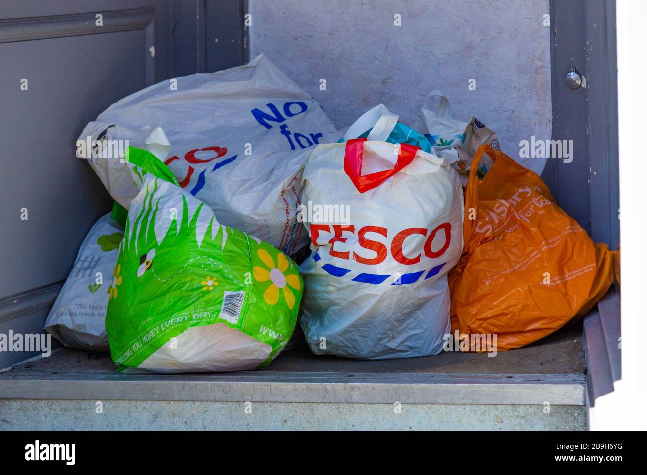 Volle Tragetaschen vor einem Wohltätigkeitsladen. Stockfoto