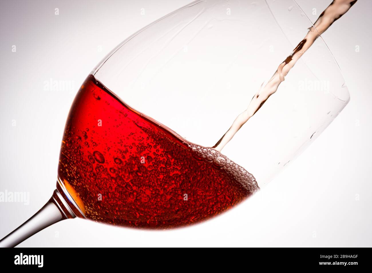 Rotwein in einem Weinglas in hinterleuchtete Nahaufnahme Stockfoto
