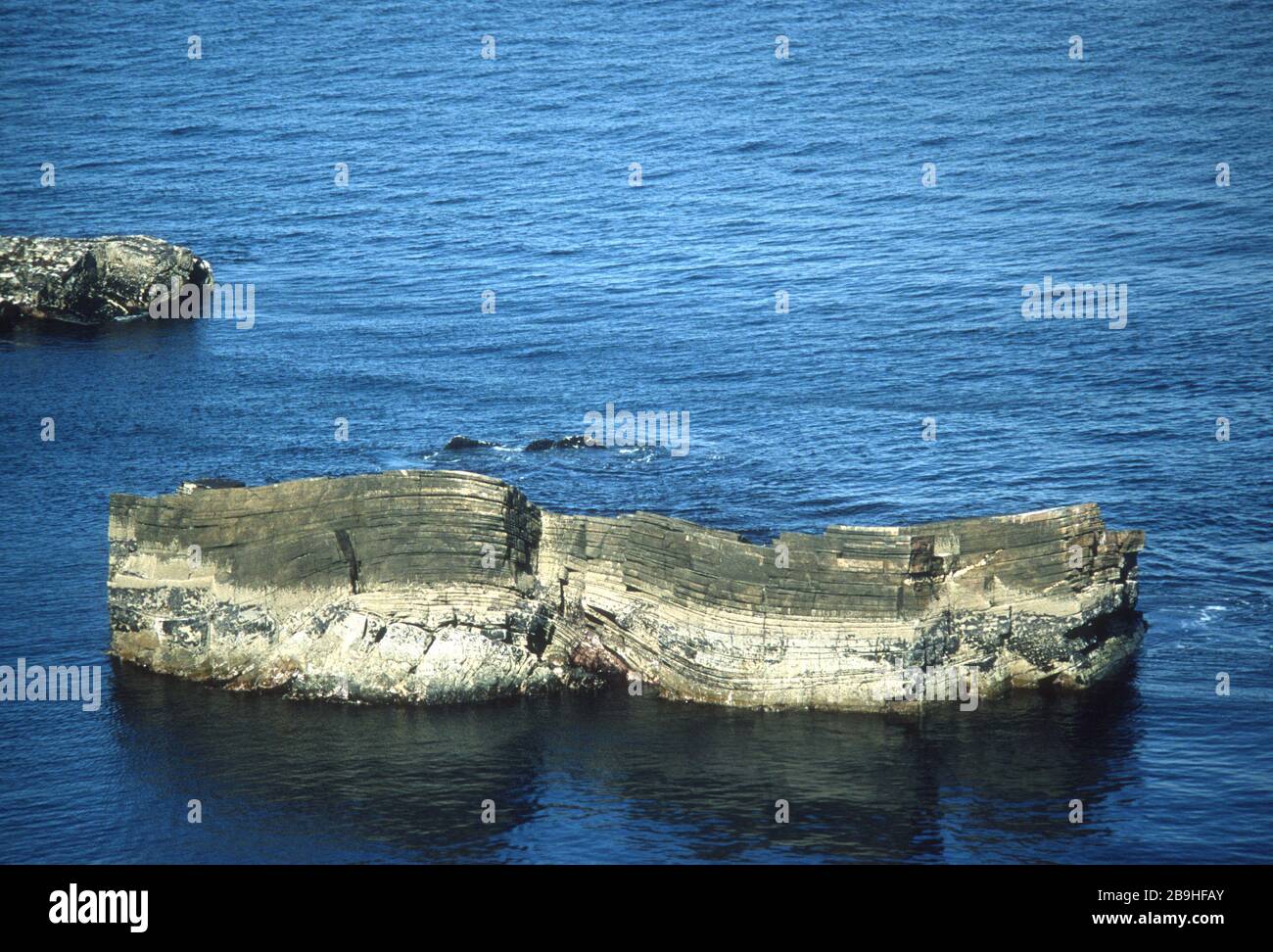 Felsen direkt vor der zerklüfteten Küste von North County Mayo, Irland, entlang der Route des Wild Atlantic Way, die ihre geologische Entstehung deutlich zeigt. Stockfoto