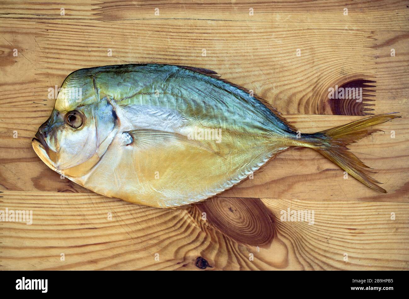 Schmackhafter geräucherter Fisch aus selene auf Holzgrund. Geräucherter Fisch ist eine wunderbare Gourmet-Mahlzeit. Stockfoto