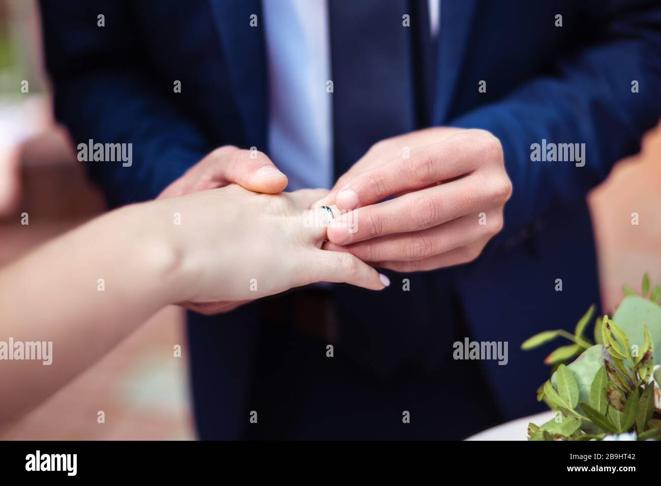 Bräutigam mit goldenem Trauring auf den Finger der Frau Stockfoto