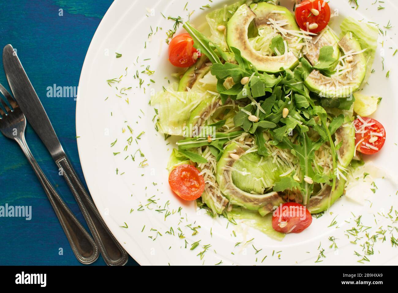 Leckerer gesunder Salat mit Avocado und Arugula von oben Stockfoto