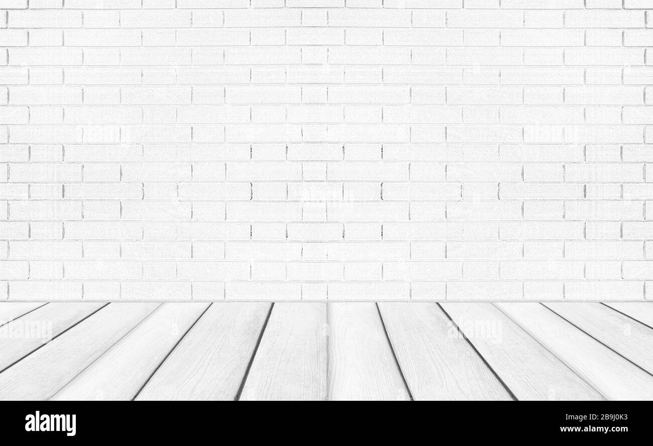 Weiße leere Holzböden mit Backstein-Wandhintergrund. Studio- oder Bürofläche. Stockfoto