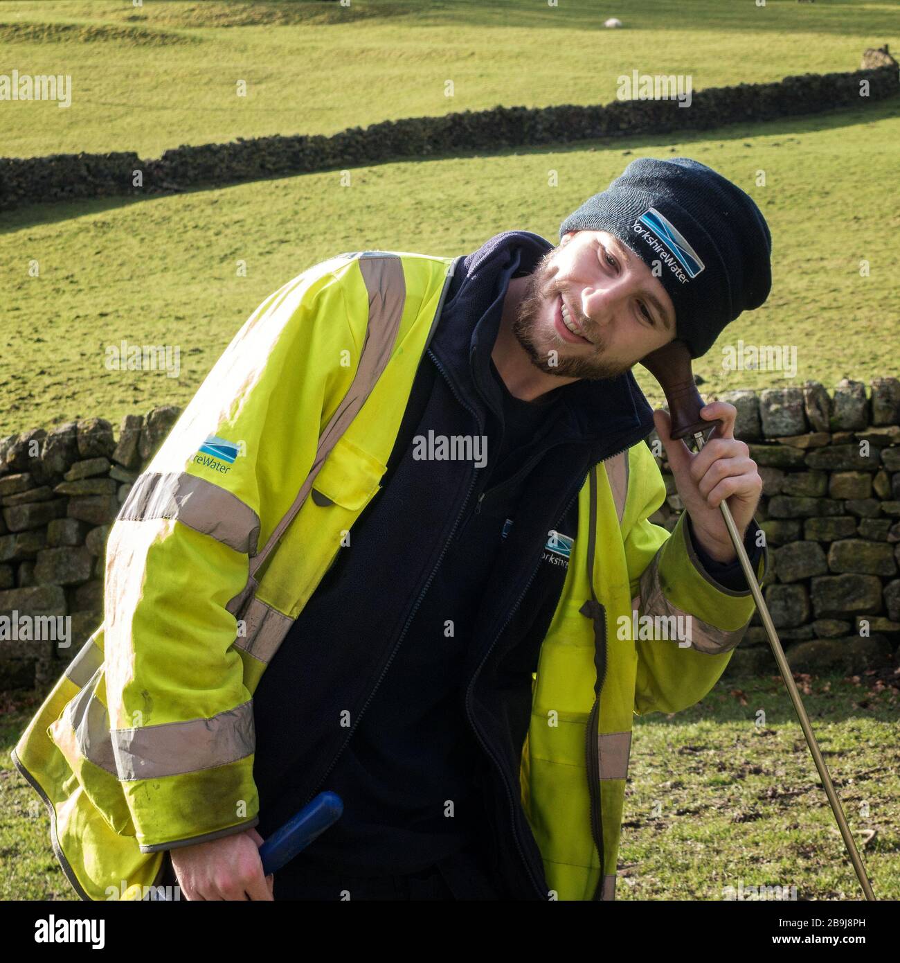 Mann aus Yorkshire Water mit einem hörenden Stock - ein Metall- oder Holzpfosten mit Ohrstück wird seit Jahrhunderten verwendet, um auf Wasserlecks zu hören, Großbritannien Stockfoto