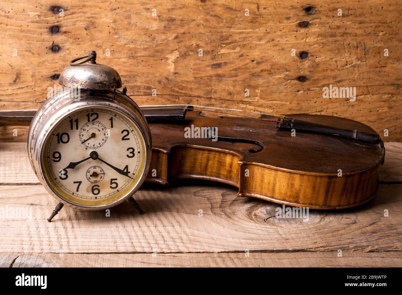 Antike Uhr und alte Geige über Vintage-Holztisch - selektiver Fokus, Kopierraum Stockfoto