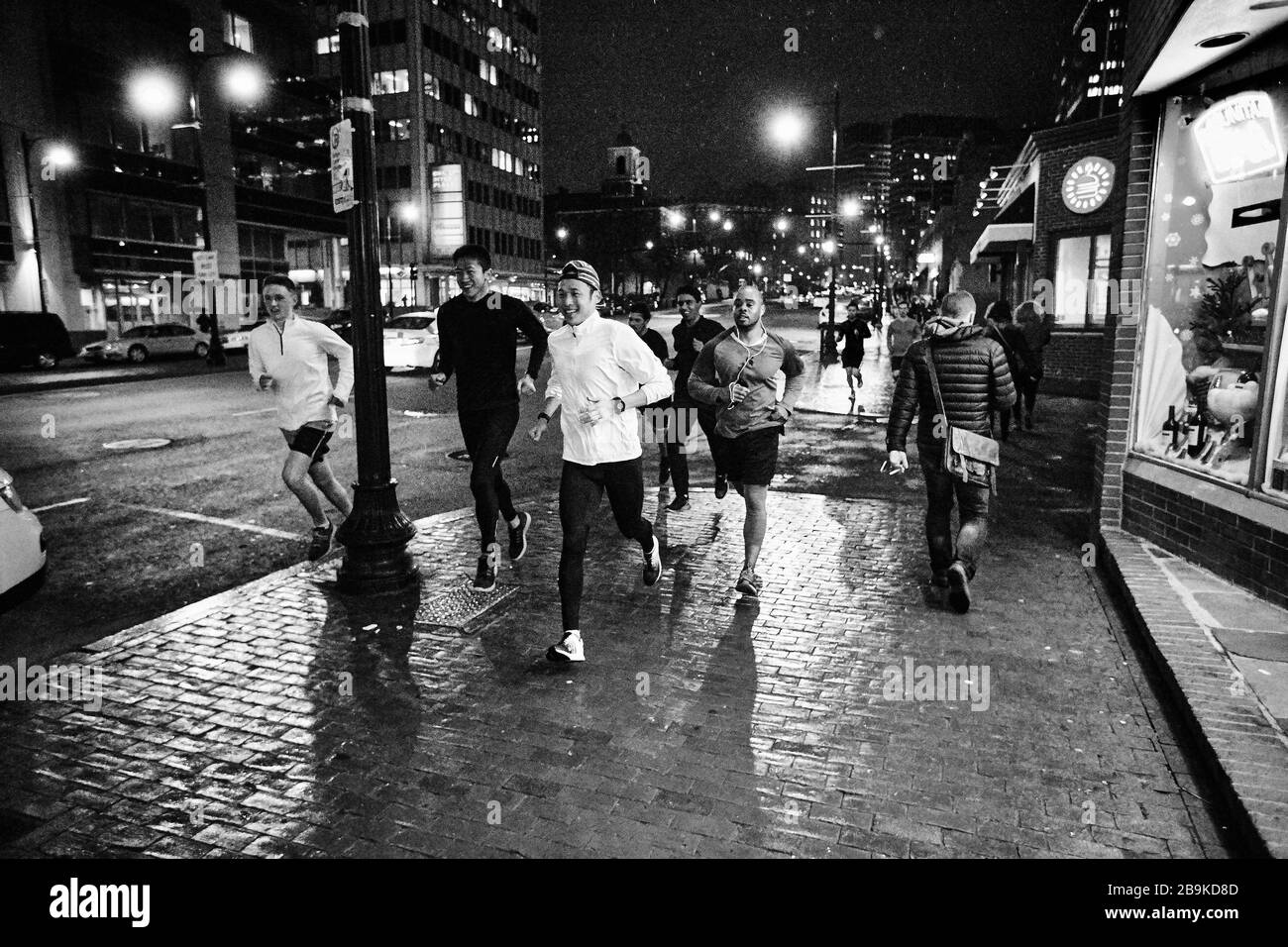 Eine Gruppe Läufer läuft nachts durch Boston. Stockfoto