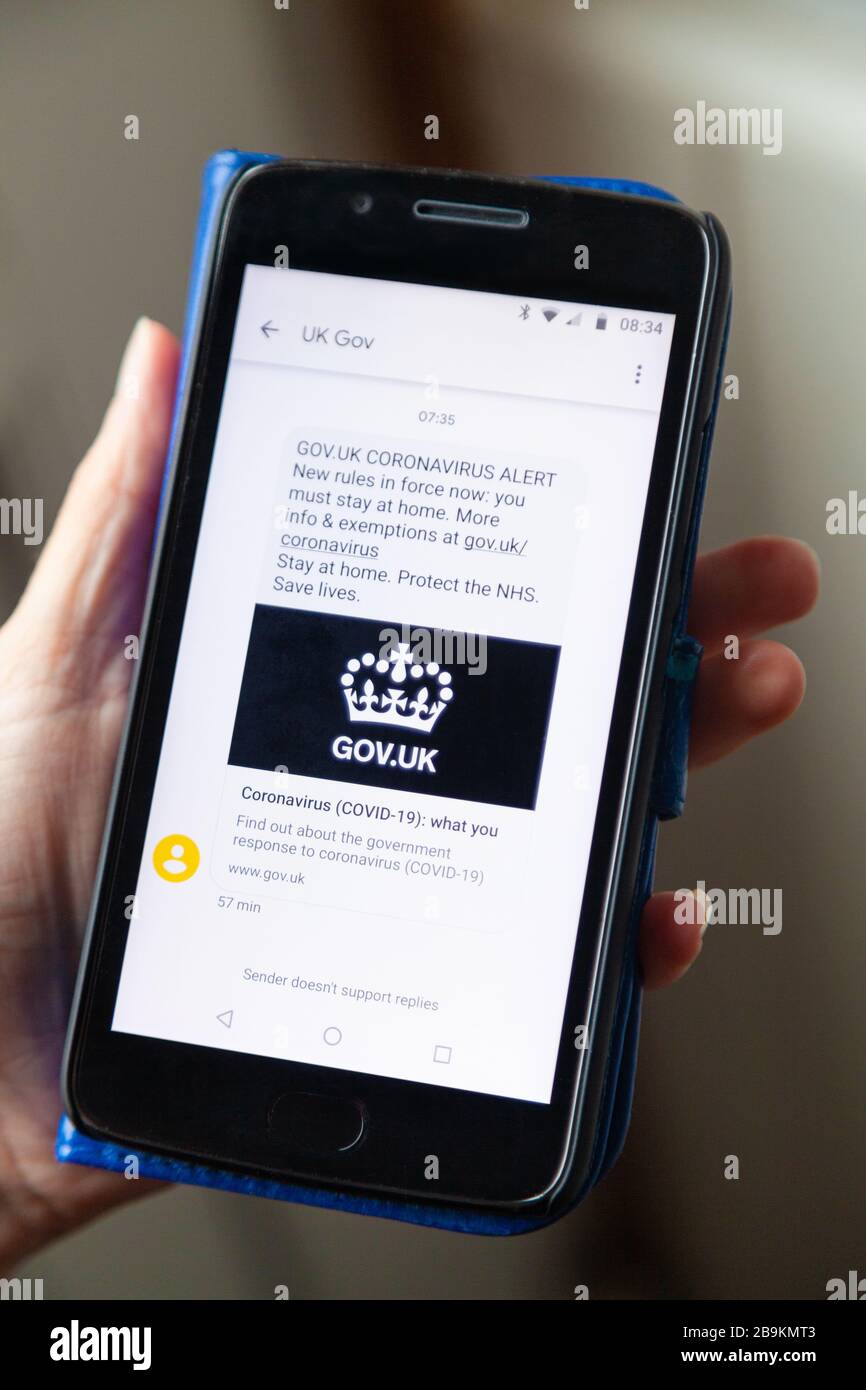 Coronavirus SMS-Benachrichtigung der britischen Regierung auf dem Handy Stockfoto