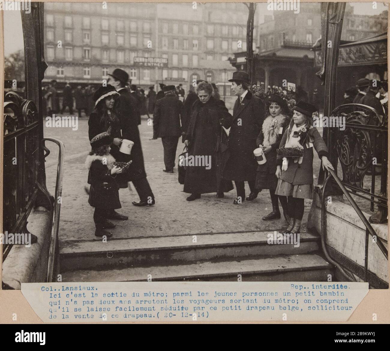 Kinder, die am 20. Dezember 1914 kleine belgische Flaggen an der U-Bahn-Ausfahrt verkaufen. Hier befindet sich die U-Bahn-Ausfahrt; unter jungen Leuten ein kleines Kleinkind, das die zwei Jahre nicht aus den U-Bahn-Passagieren herausgehalten hat; wir verstehen, dass es leicht von dieser kleinen belgischen Flagge verführt wird, Solicitor des Verkaufs dieser Flagge (20-12-14) Guerre 1914-1918. Enfants vendant de petits drapeaux belges à la sortie du métro. Paris, le 20 décembre 1914. Paris, musée Carnavalet. Stockfoto