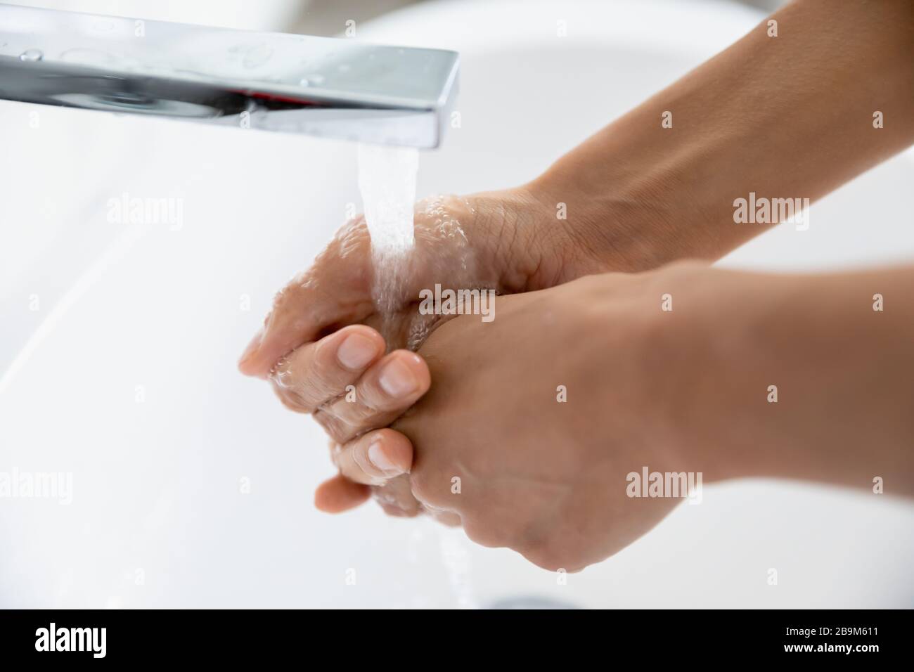 Weibliche Hände unter fließendem Wasser in der Nahansicht waschen Stockfoto