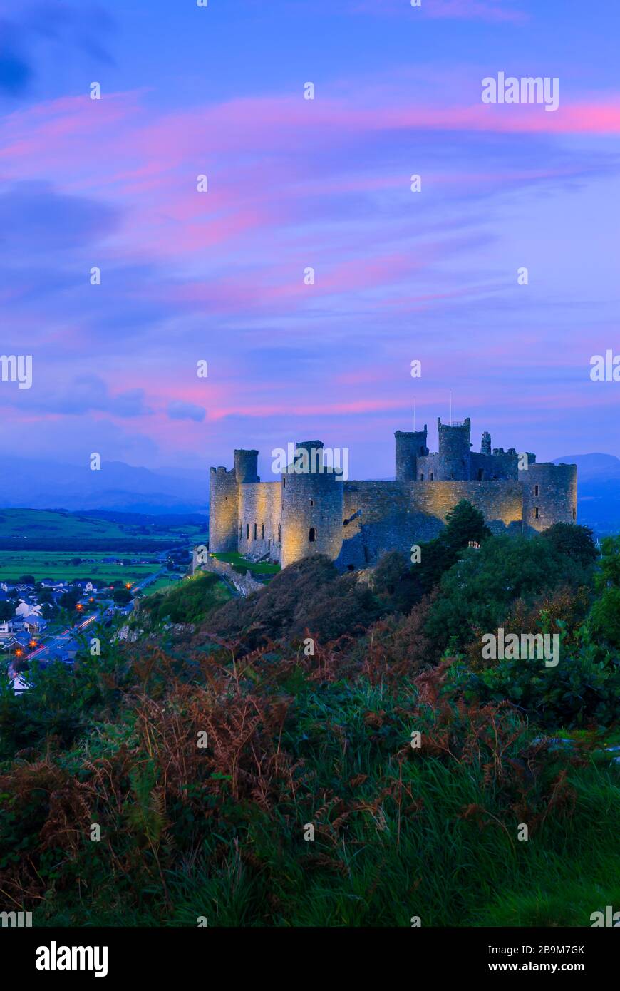 Moody Pink Himmel auf Harlech Castle in der frühen Dämmerung Harlech Gwynedd Wales Stockfoto