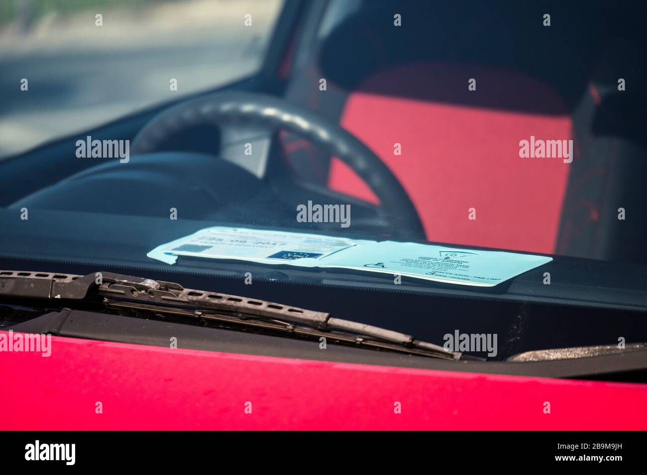 Blaue Plakette für Behinderte Parkaufkleber auf der Windschutzscheibe des Autos Stockfoto