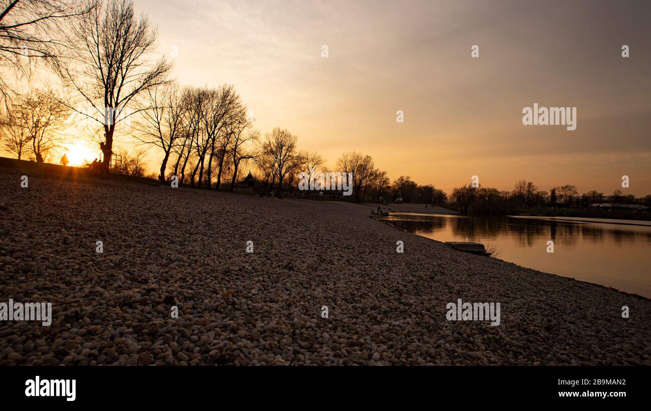 Menschen am ufer des jarun-Sees, die den Sonnenuntergang nur wenige Tage vor der Corona-Virus-Sperre in Zagreb genießen und gesellschaftliche Zusammenkünfte verboten waren Stockfoto