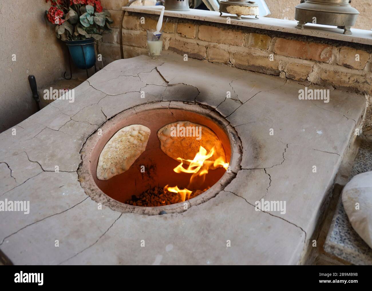 Brotbacken im traditionellen Tandoor Ofen im Khaneye Amoo Mash Reza Haus (Haus des Onkels Mesh Reza) im Dorf Kavirabad, Varamin, Teheran Stockfoto