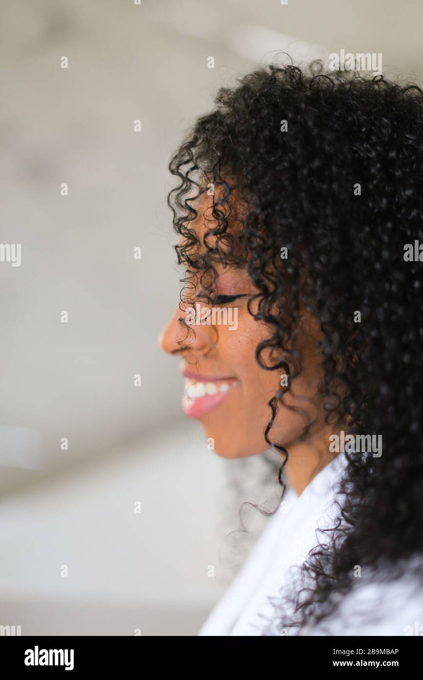 Porträt eines lächelnden schwarzen, lockig behaarten Mädchens. Stockfoto