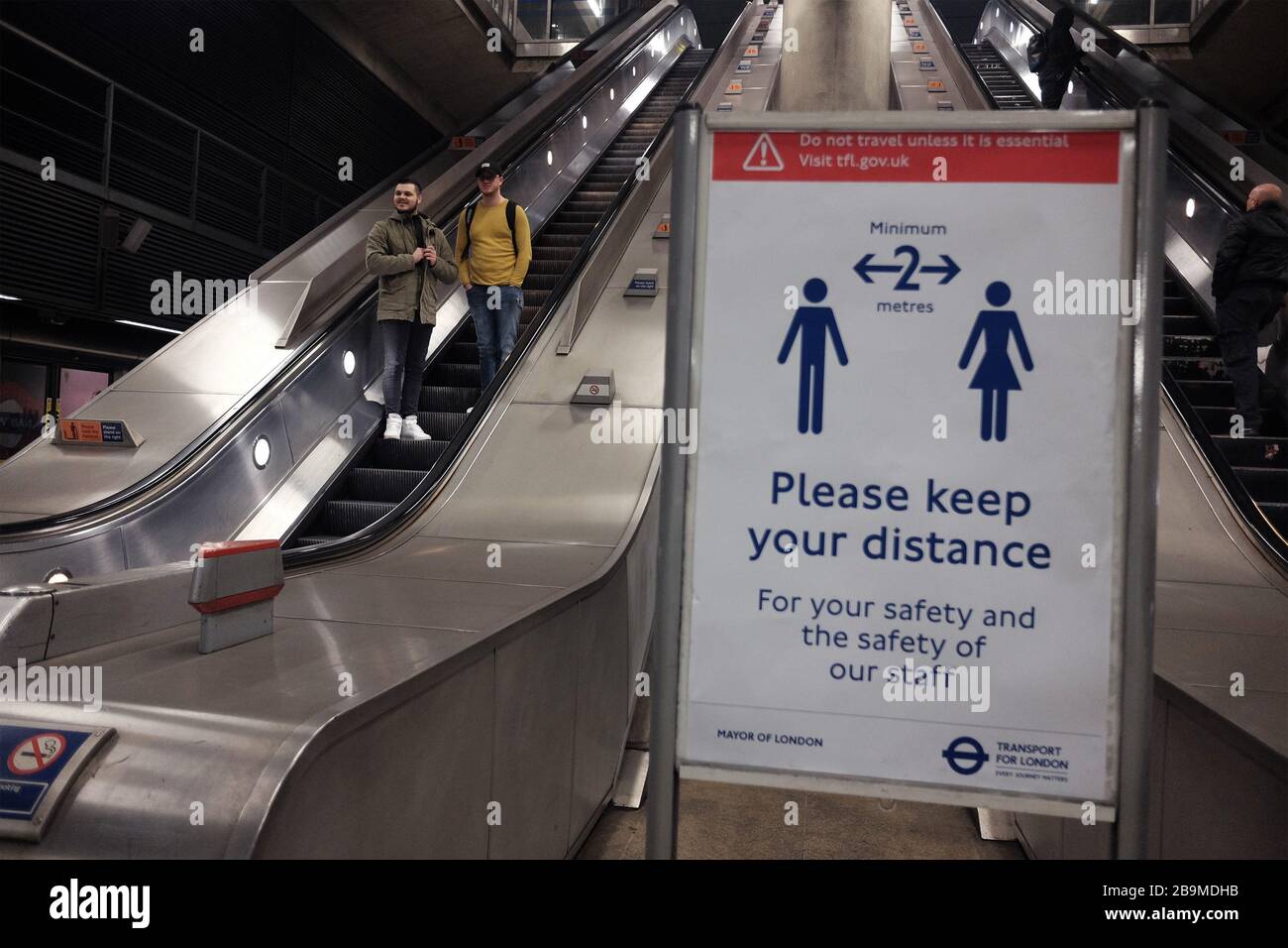 Ein Zeichen für Pendler, ihre Entfernung zu halten, am U-Bahnhof Canary Wharf, am Tag nachdem Premierminister Boris Johnson das Vereinigte Königreich in Sperrstellung versetzt hatte, um die Ausbreitung des Coronavirus einzudämmen. Stockfoto