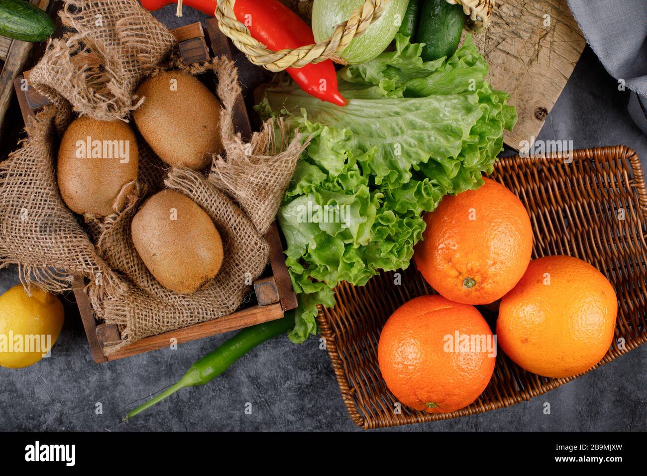 Kiwies und Orangen in rustikalen Holztabletts. Stockfoto