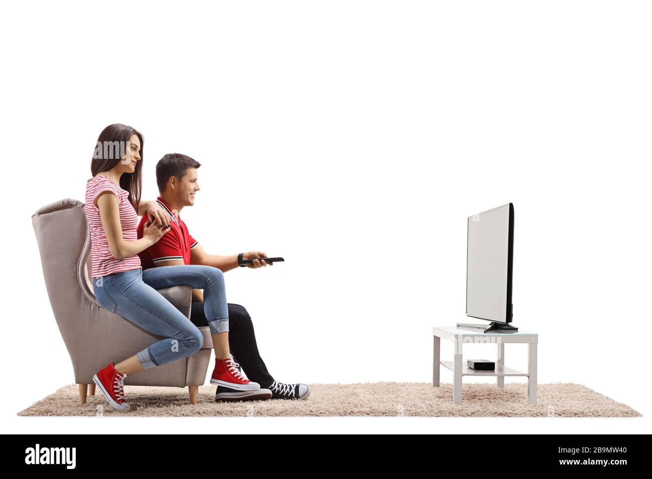 Ein Paar sitzt in einem Sessel und beobachtet Fernsehen isoliert auf weißem Hintergrund Stockfoto