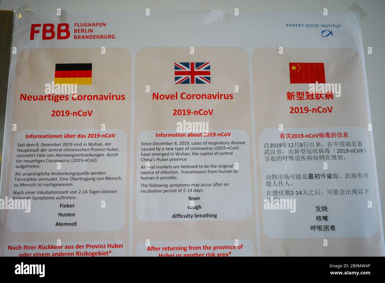 Flughafen Berlin Schönefeld SXF, Deutschland: Warnung offizielle Plakatwand informiert über Coronavirus COVID-19 für Flughafenreisende. In Deutsch, Englisch, Chinesisch Stockfoto