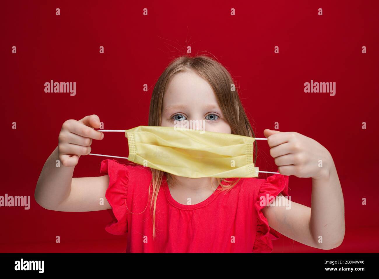 Süßes kleines Mädchen, das mit Sicherheitsmedizin posiert, maskiert den bakteriellen Schutz des Gesundheitswesens Stockfoto