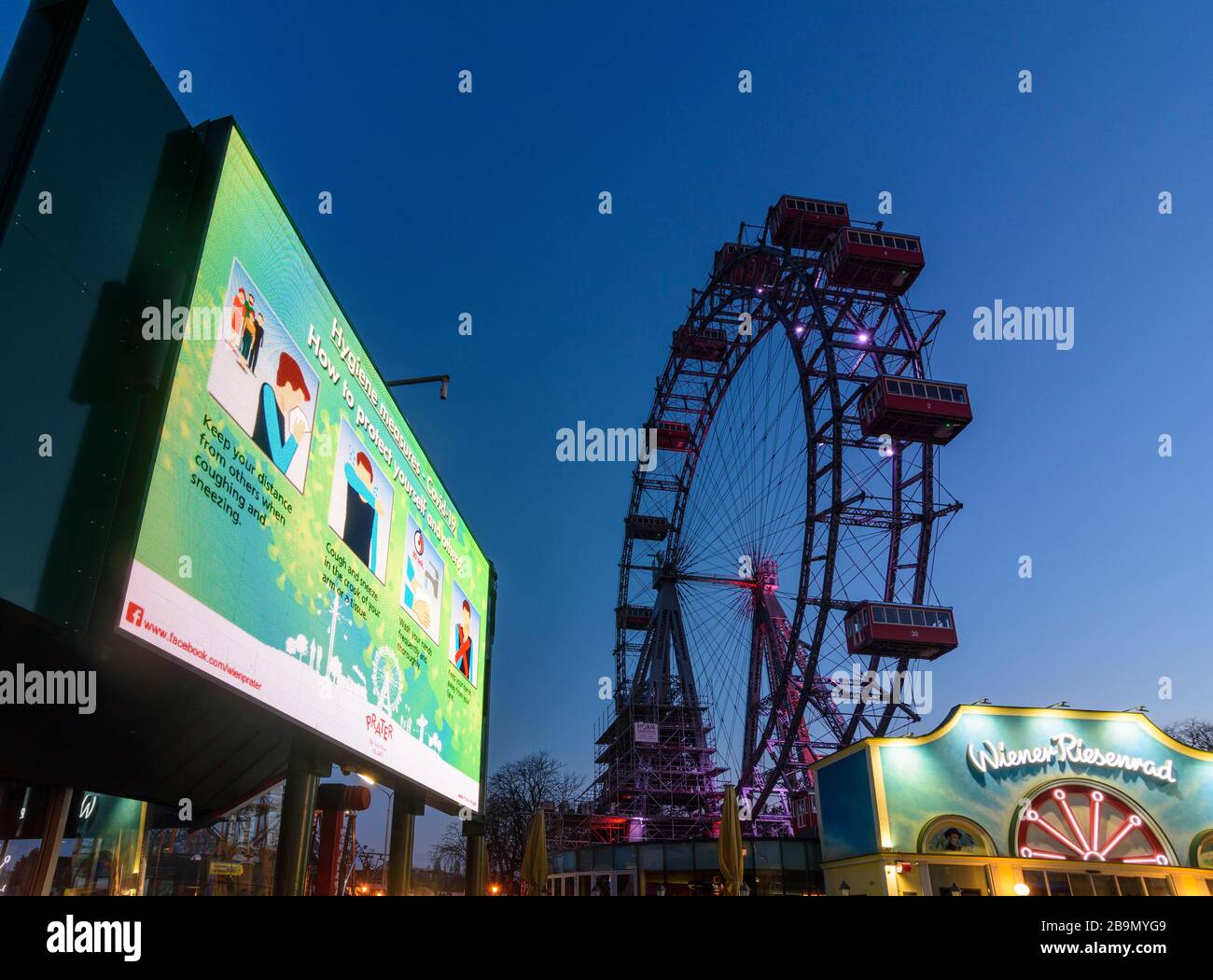 Wien, Wien: Informationsvideowand mit Informationen über Hygienemaßnahmen ("wie man sich und andere schützt") auf Englisch, Ferris Wheel am Prater Stockfoto